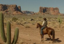 Um cowboy solitário em seu cavalo observando o pôr do sol em um desfiladeiro do Velho Oeste, com cactos e formações rochosas ao fundo, em um estilo de arte realista de videogame.